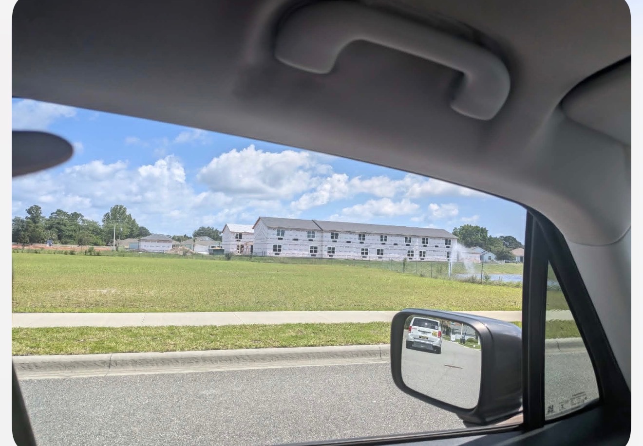 Apartment buildings under construction at American Village, Palm Coast P-Section, seen from across the lot. June 2026.